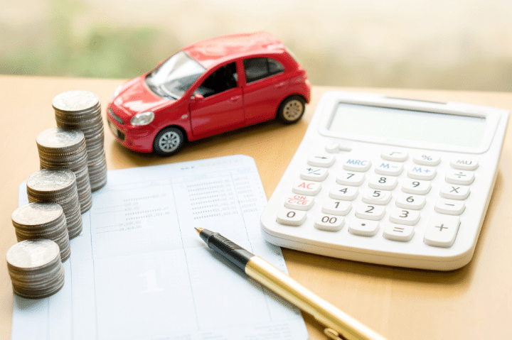 مجموعة من النقود و سيارة وآلة حاسبة لحساب معدلات الفائدة على قروض السيارات في الإمارات