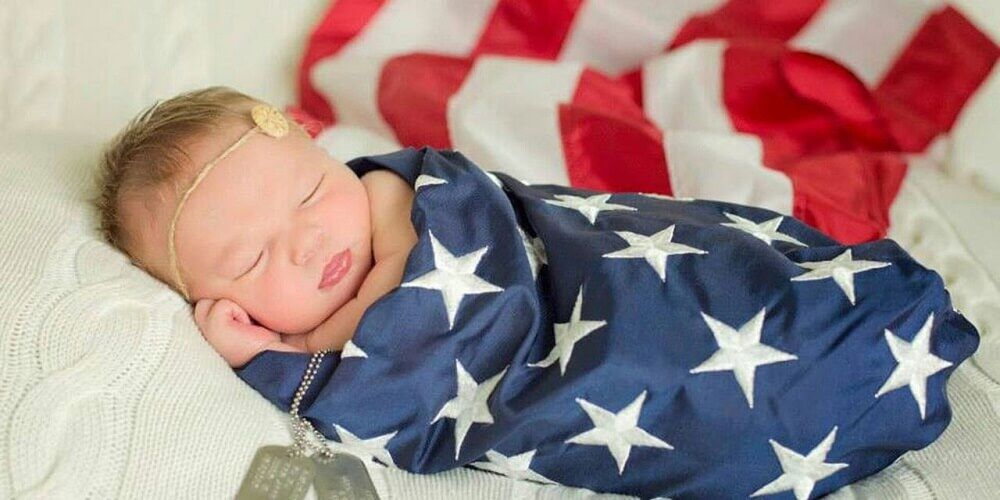 طفلة نائمة مغطاة بعلم أمريكا - الولادة في أمريكا 