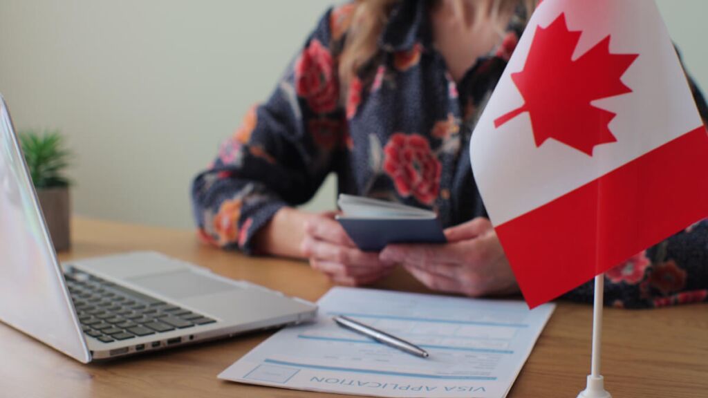 علم كندا مع استمارة طلب للحصول على فيزا للاستثمار لكندا - فتح مشروع تجاري في كندا 